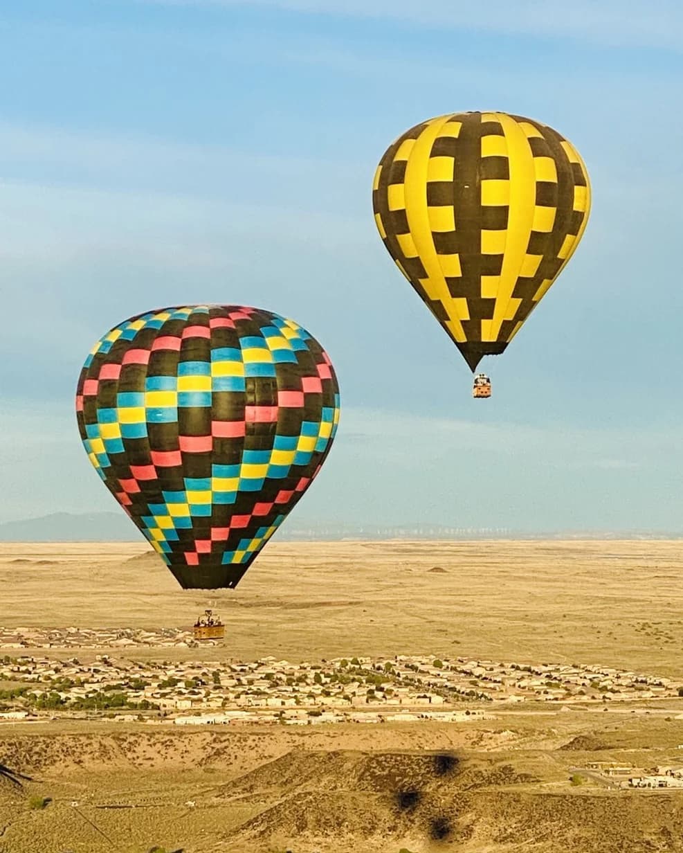 Colorful hot-air balloons flying above Albuquerque’s desert landscape