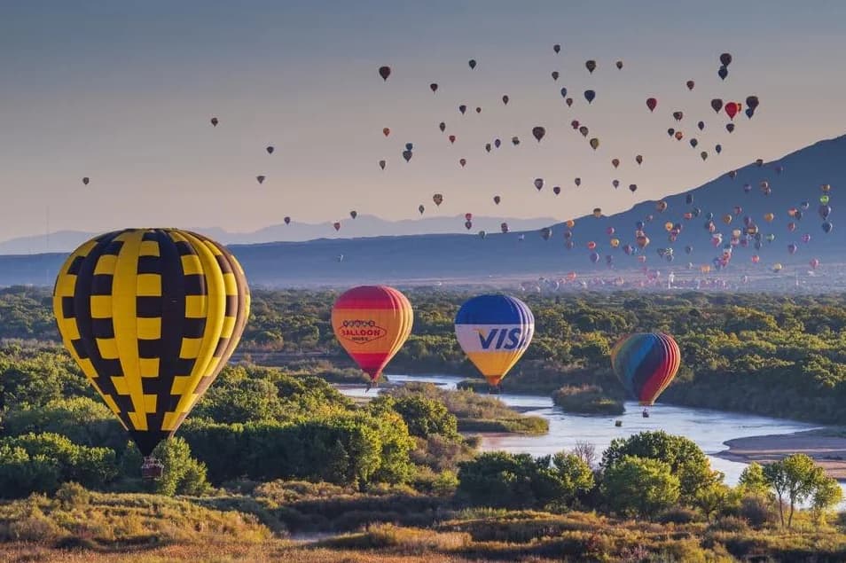 Hot-air balloons above the Rio Grande and wooded Bosque in Albuquerque