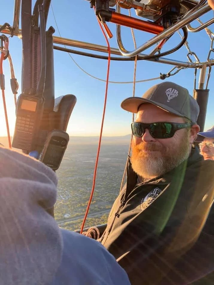 Pilot Art Moller at the balloon controls with the landscape behind him